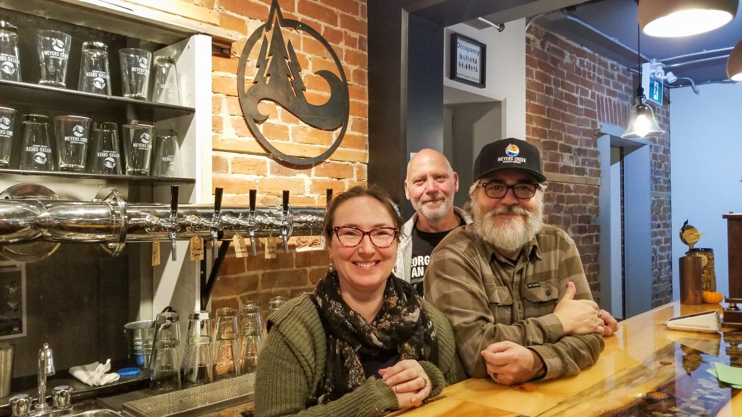 a group of people sitting at a bar posing for a picture.