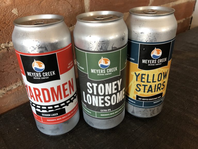 three cans of beer sitting on a table.
