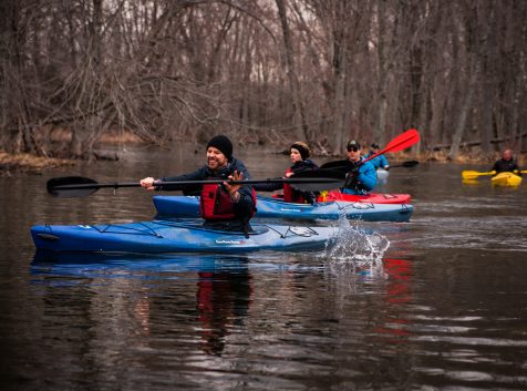 a group of people in kayaks paddling down a river.