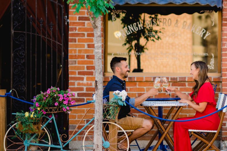 a man and a woman sitting at a table drinking wine.