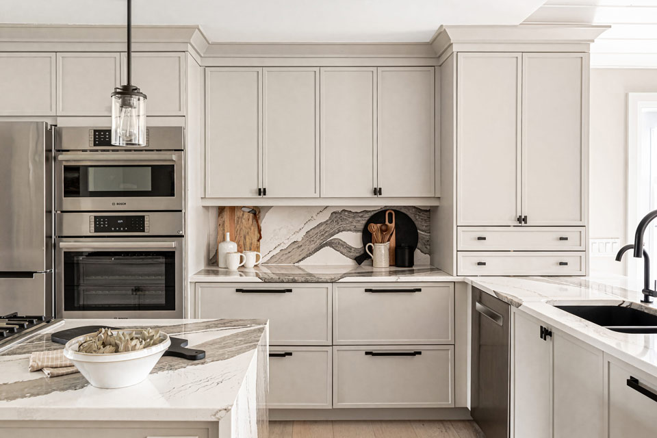 a white kitchen with a marble counter top.