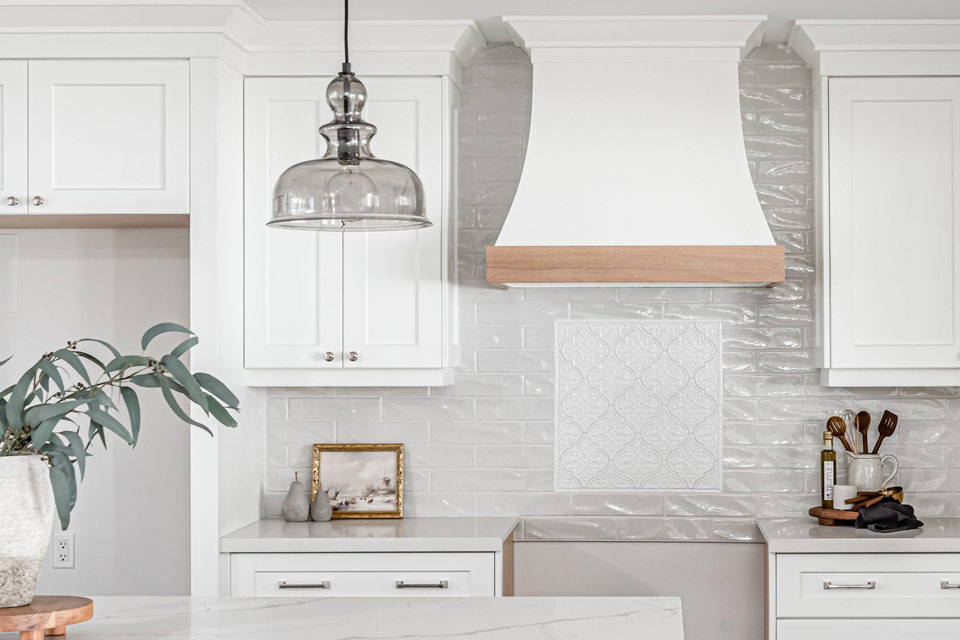 a kitchen with white cabinets and a marble counter top.
