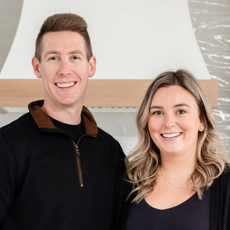 a man and a woman standing in a kitchen.