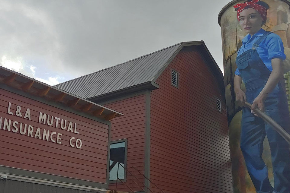 a large painting of a woman is on the side of a red building.