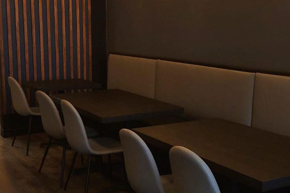 a row of white chairs sitting next to a wooden table.