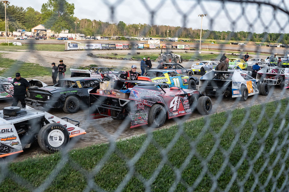a group of cars parked next to each other on a dirt road.