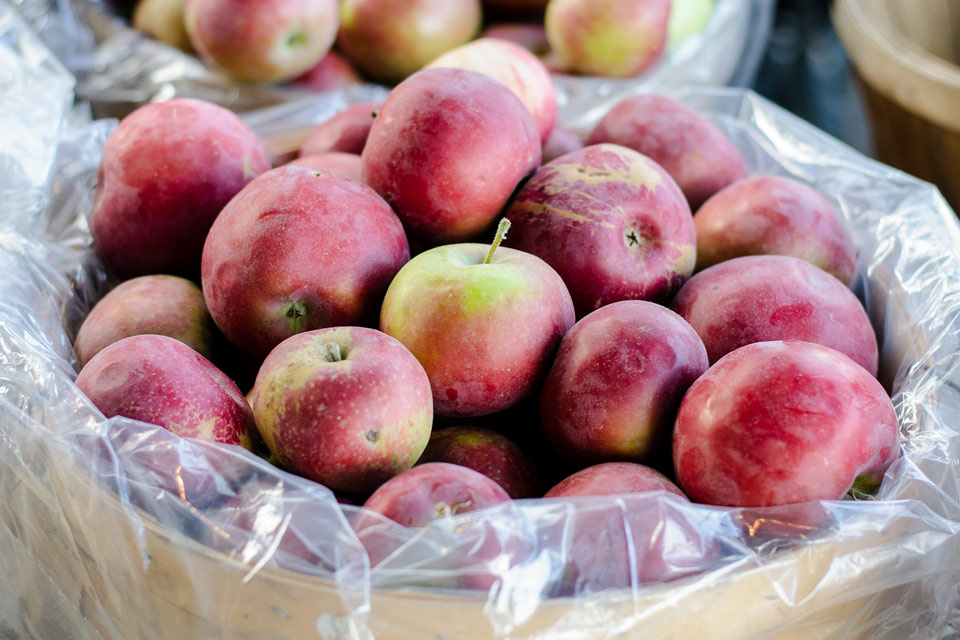 a bunch of apples in a plastic bag.