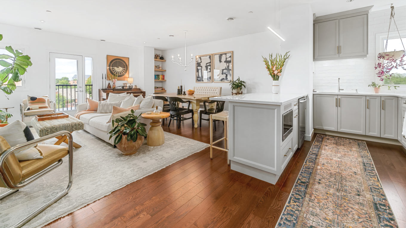 a living room filled with furniture and a kitchen.