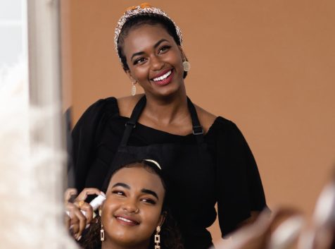 a woman is getting her hair done by another woman.