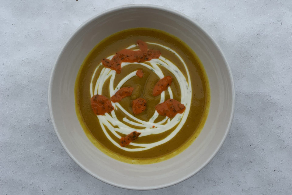 a white bowl filled with soup on top of a table.