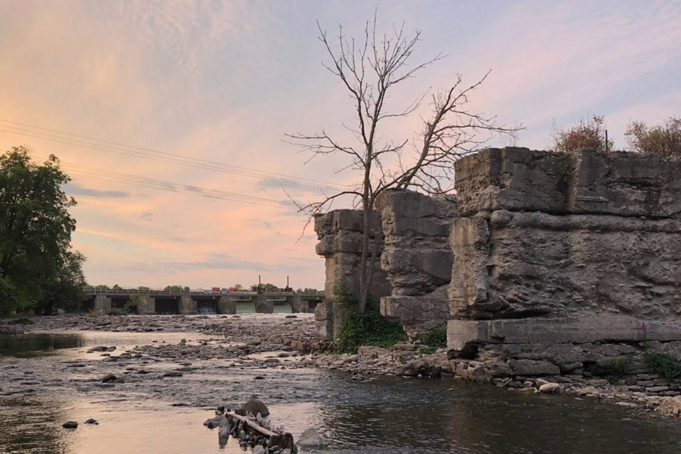 a body of water with rocks and trees in the background.