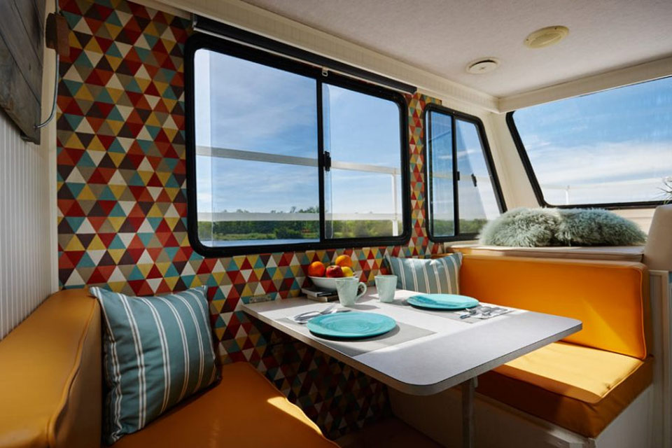 a dining area with a table and a bench in front of a window.