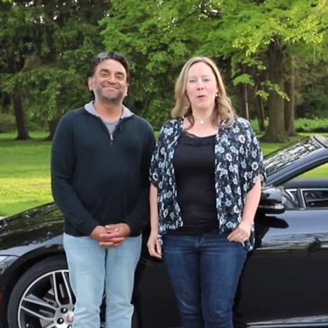 a man and a woman standing next to a car.