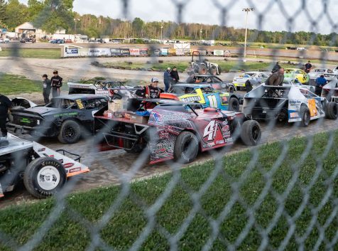 a group of cars parked next to each other on a dirt road.
