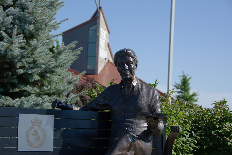 a statue of a man sitting on a bench.