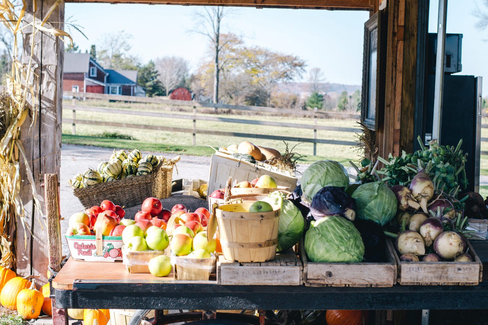 a wooden table topped with lots of fruits and vegetables.
