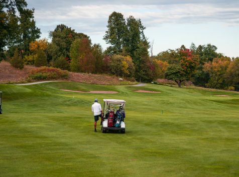 two golf carts on a golf course.