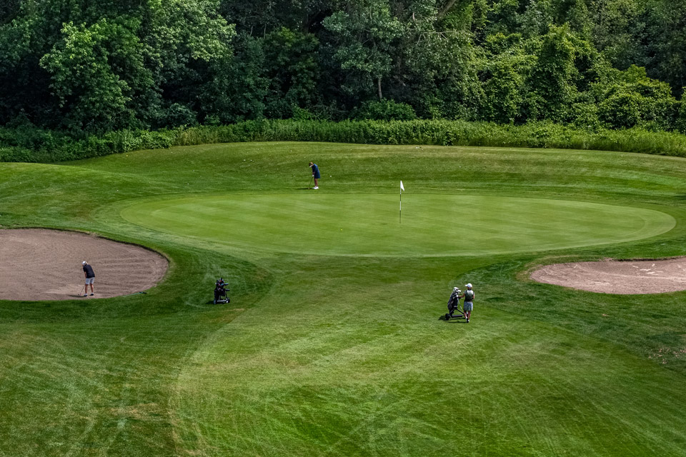 an aerial view of a golf course with sand bunkers.