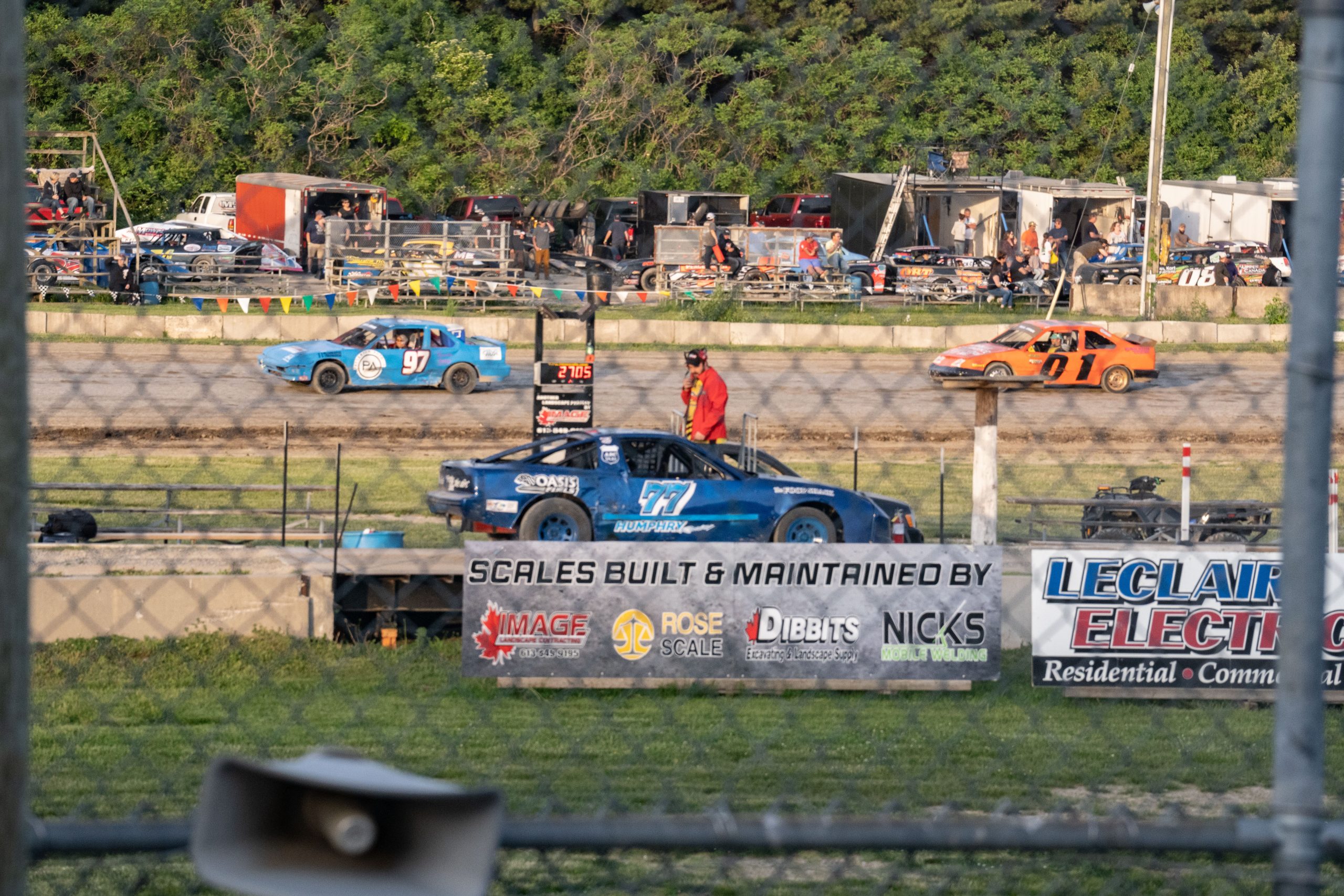 A dirt track with several cars on the track.
