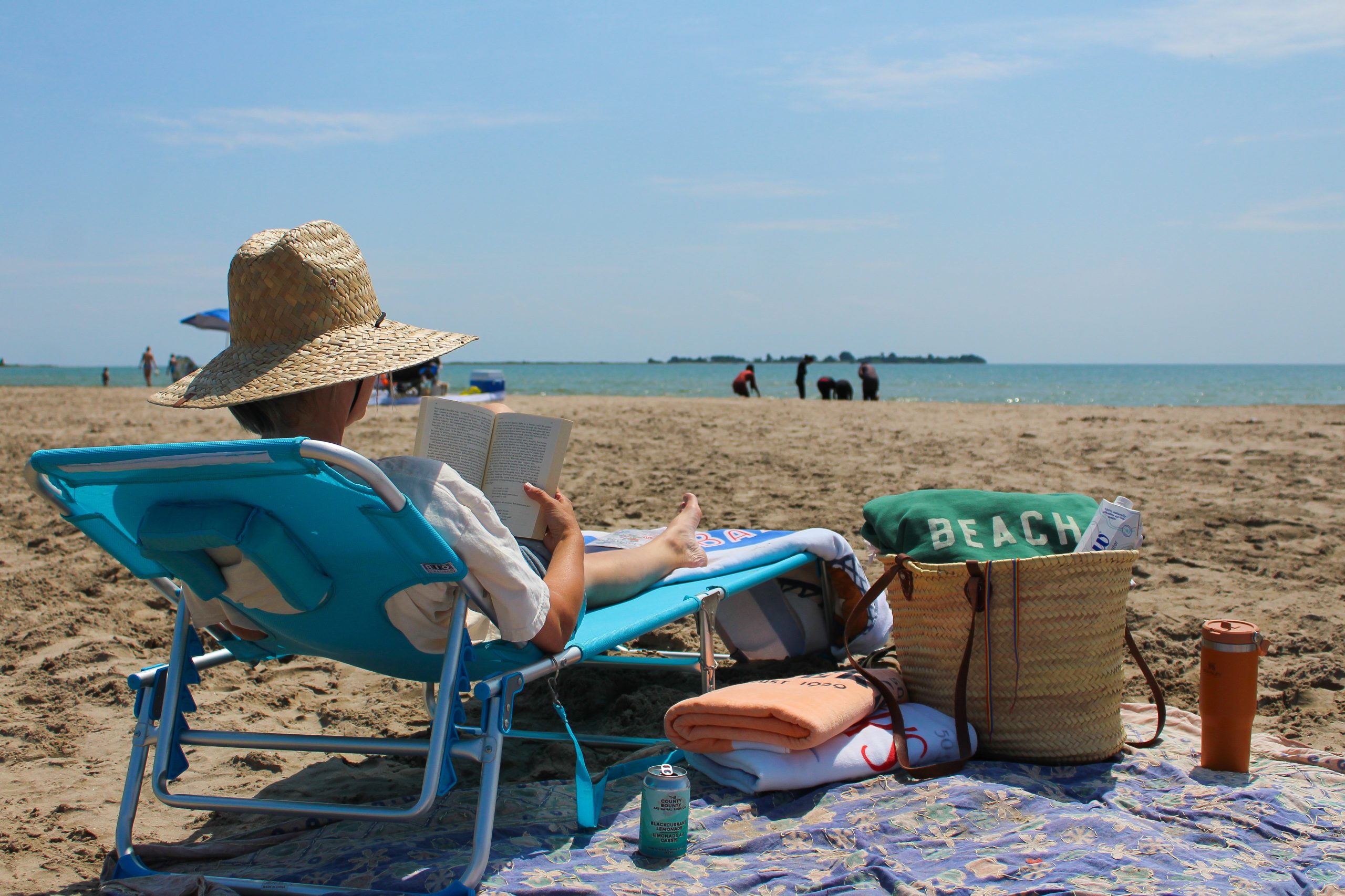 A person reading a book on a beach.