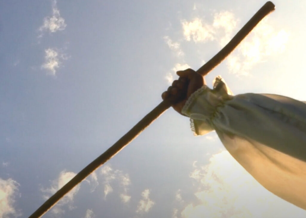 a hand holding up a spear into the sky