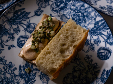 fresh bread with spreads on it on an ornate blue and white plate