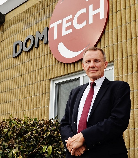 man in a suit and tie posing in front of an office