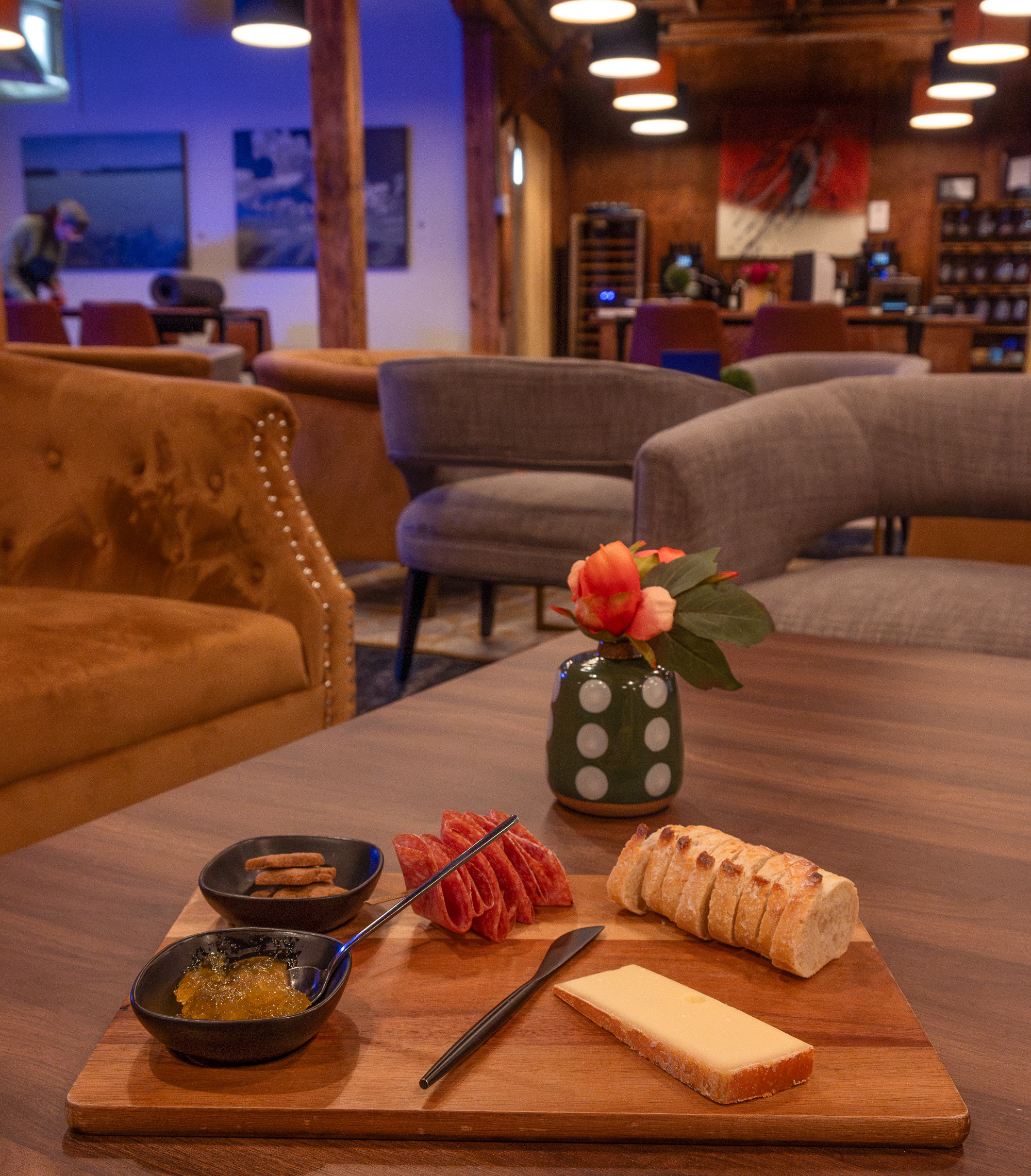 charcuterie board sitting on a coffee table in a warm, dark lounge