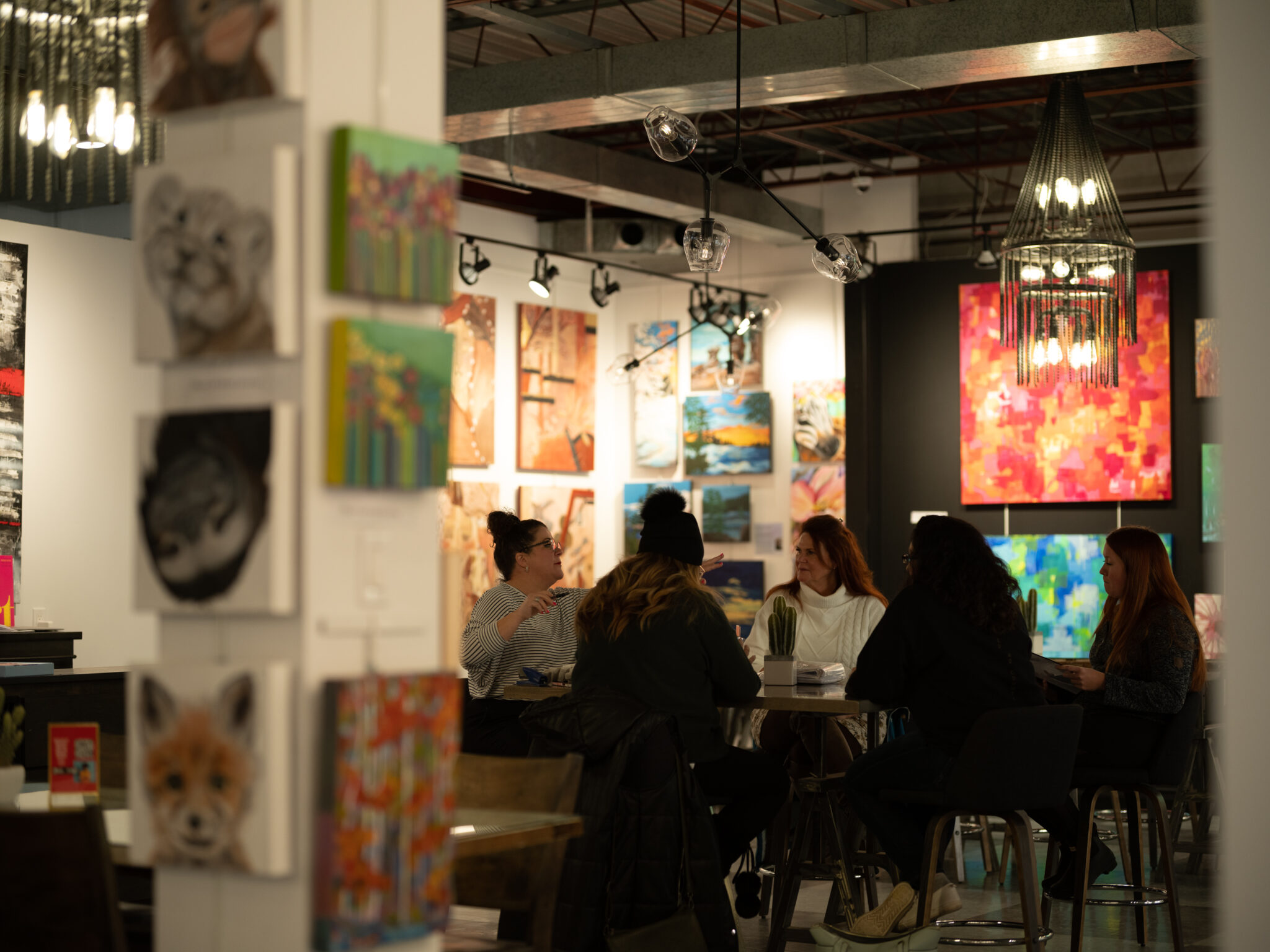 Image of an art gallery with people mingling around the art