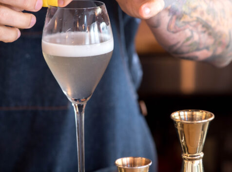 Image of a bartender putting the finishing touch on a cocktail