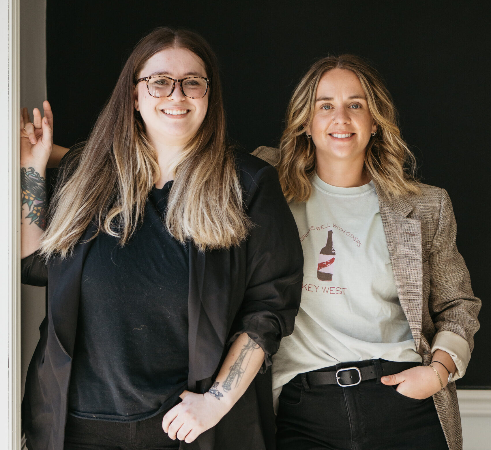 two women (light skin, blonde hair) wearing blazers posing for a headshot