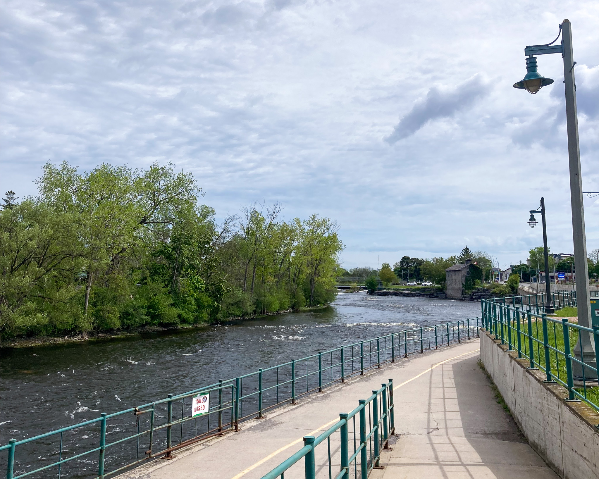 a paved walking and cycling trail running alongside a river