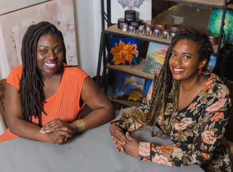 two women sitting and posing for a photo