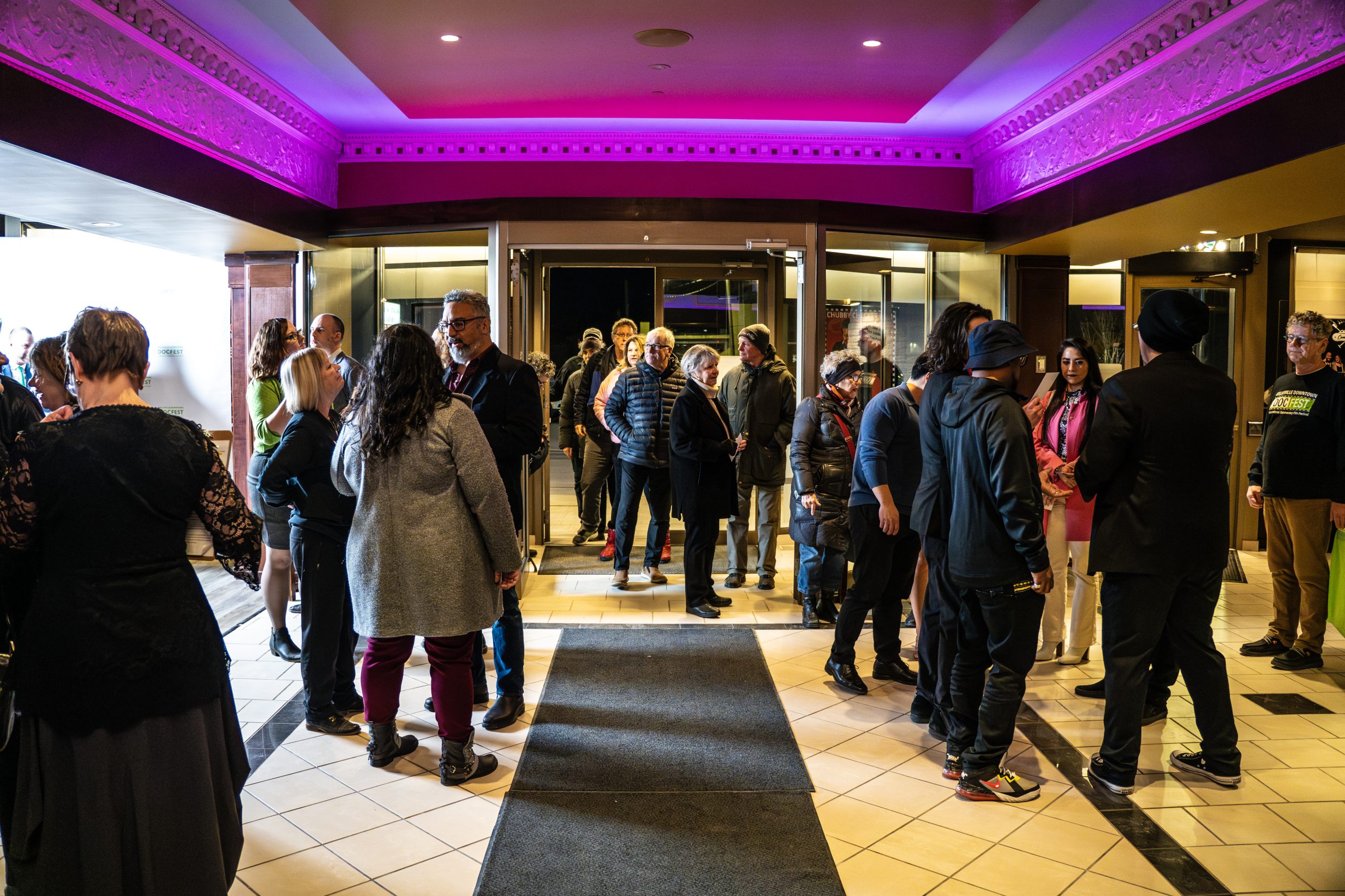 a crowd of people gathering in the entrance of a theatre