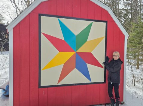 artist pat dubyk poses with one of her barn quilts along the greater napanee barn quilt trail