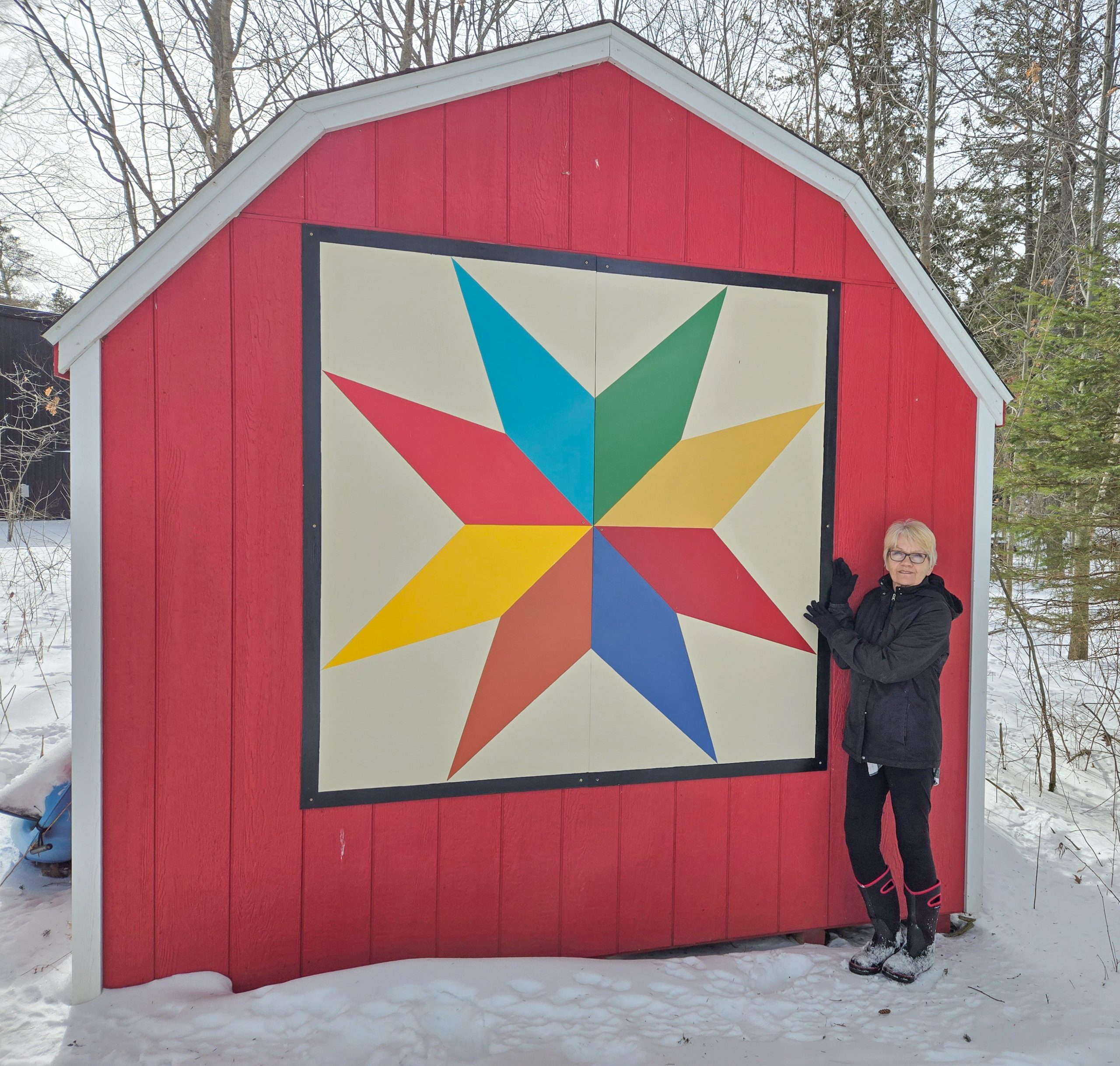 artist pat dubyk poses with one of her barn quilts along the greater napanee barn quilt trail