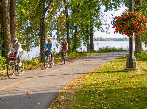 three people cycling in the bay of quinte along a waterfront trail