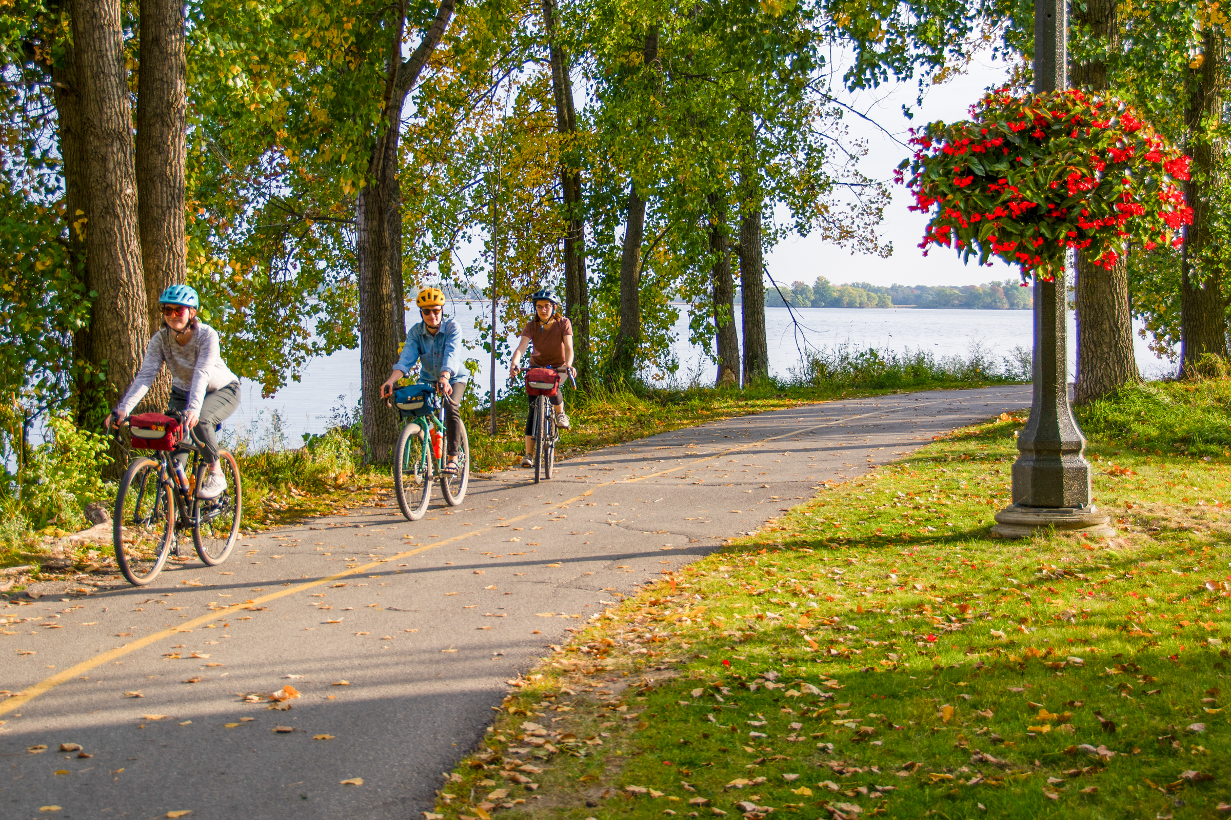 three people cycling in the bay of quinte along a waterfront trail