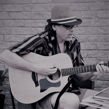 man playing guitar with hat on