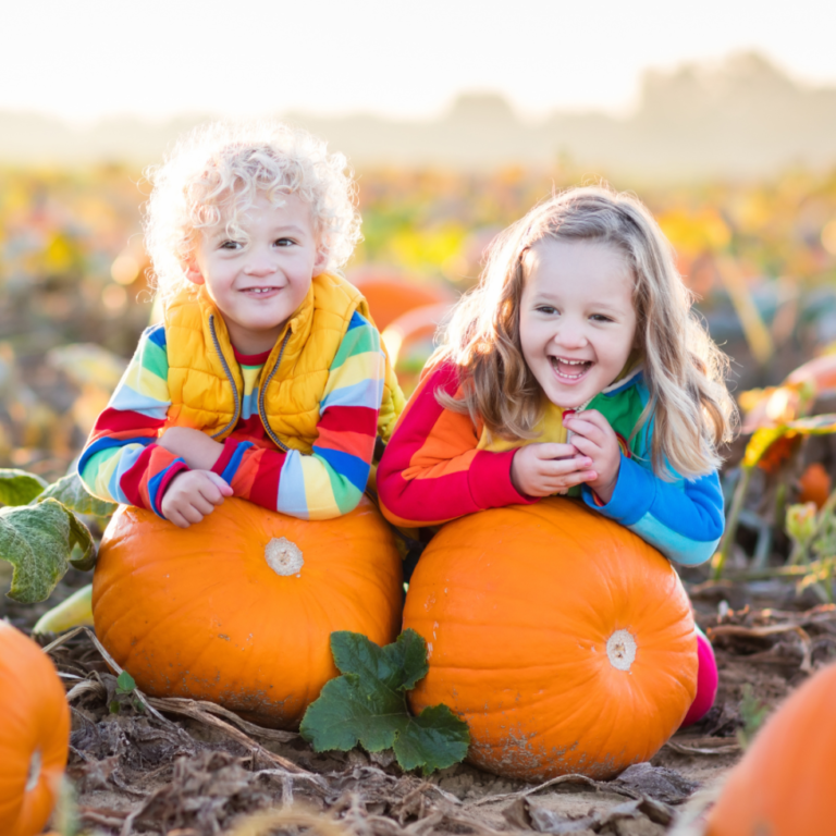 kids laying on pumpkins