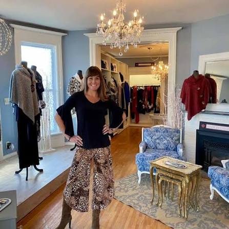 Image of a woman standing with her hands on hips in a clothing store